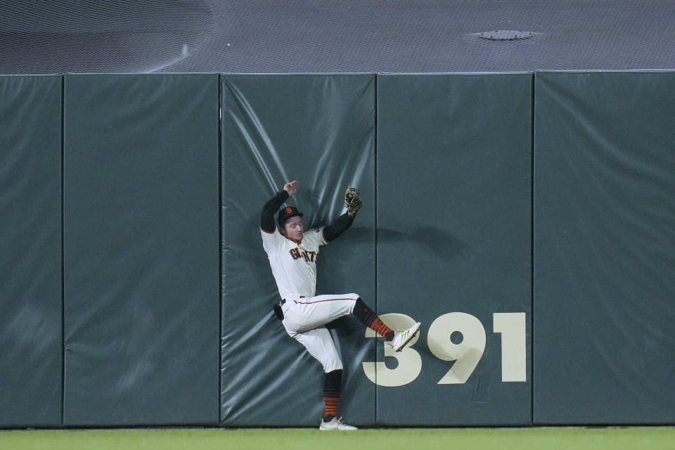 San Francisco Giants center fielder Bryce Johnson collides with the wall while catching a fly ball hit by Los Angeles Dodgers' Freddie Freeman during the fourth inning of a baseball game in San Francisco, Wednesday, April 12, 2023. (AP Photo/Godofredo A. Vásquez)