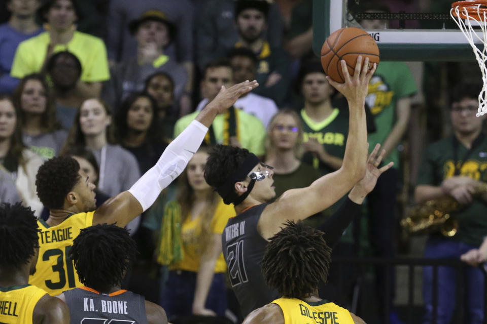 Oklahoma State guard Lindy Waters III, right, scores past Baylor guard MaCio Teague, left, during the second half of an NCAA college basketball game Saturday, Feb. 8, 2020, in Waco, Texas. (AP Photo/Rod Aydelotte)