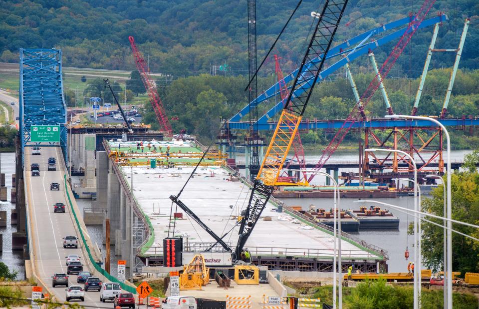 Workers continue construction on the deck of the new eastbound section of the McClugage Bridge on Thursday, Sept. 28, 2023 while also building the on-ramp from northbound Rt. 29 and the new arch that will stretch across the middle of the Illinois River.