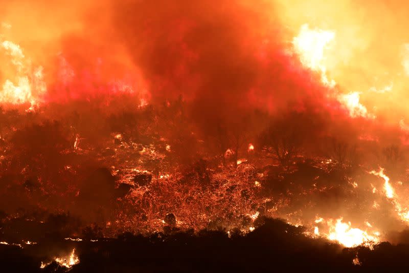 FILE PHOTO: A wildfire dubbed the Cave Fire burns in the hills of Santa Barbara, California,