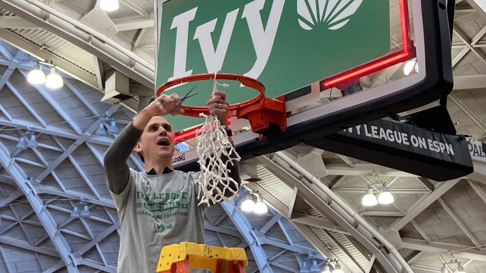 Princeton basketball coach Mitch Henderson cuts down the net at Jadwin Gym.