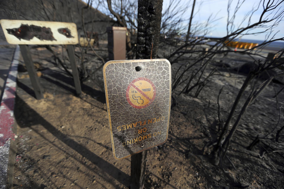 In this Tuesday, Nov. 13, 2018 photo, a sign near the entrance to the Corral Canyon Park recreation area stands amid a landscape charred by the Woolsey fire in Malibu, Calif. The Woolsey fire has charred more than 83 percent of National Park Service land within the Santa Monica Mountain National Recreational Area. Officials announced Wednesday, Nov. 14, 2018, that all trails were closed. (AP Photo/Reed Saxon)