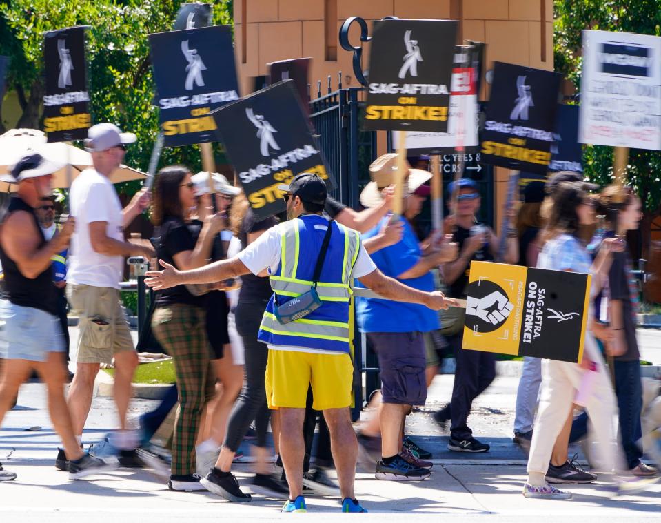 Striking members of the WGA and SA-AFTRA picket in front of Disney Studios on August 22, 2023.