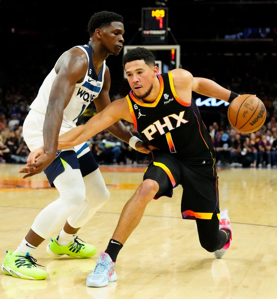Minnesota Timberwolves guard Anthony Edwards (1) pressures Phoenix Suns guard Devin Booker (1) in the second half at Footprint Center in Phoenix on Nov. 1, 2023.