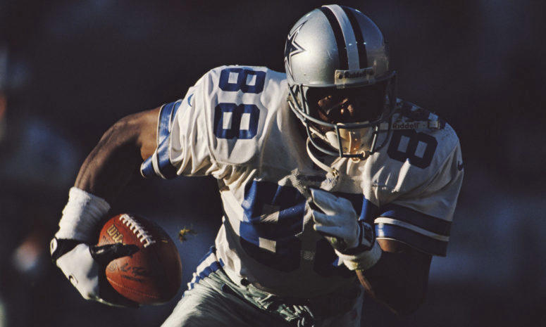 A closeup of Michael Irvin running with the football.