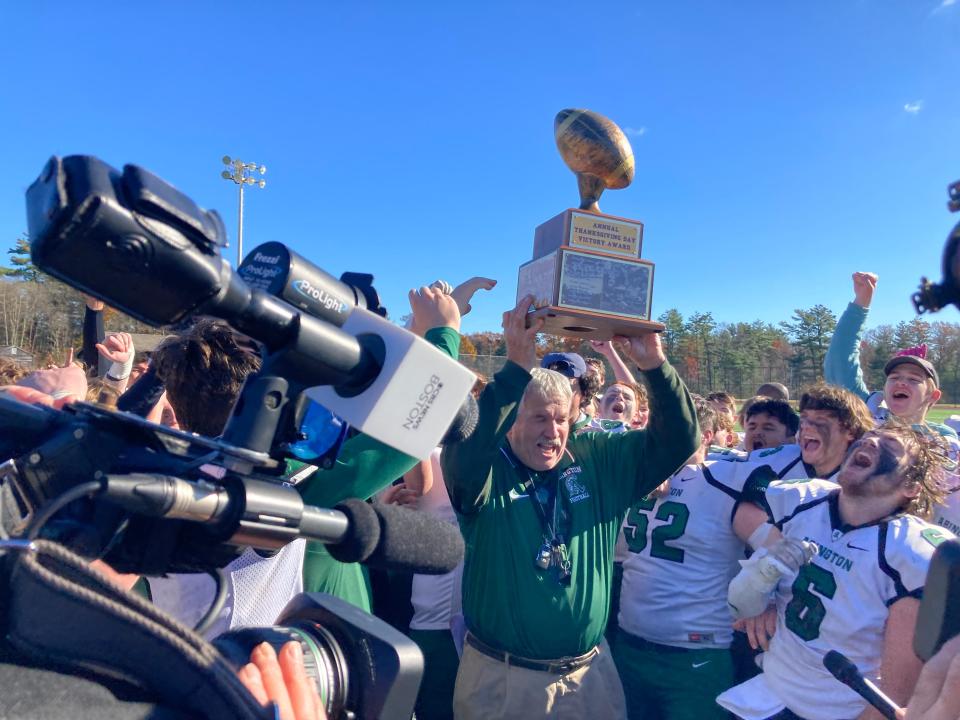 Abington High football coach Jim Kelliher raises the Thanksgiving trophy to cheers from his players after beating Whitman-Hanson, 46-6, on the road on Thursday, Nov. 23, 2023. Kelliher retired after 50 seasons coaching the Green Wave.