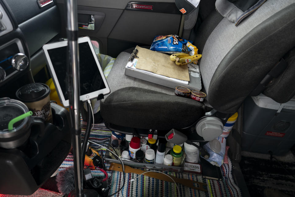 In this April 5, 2020, photo, the front passenger seat of Sammy Lloyd's 2014 Kenworth W900 semitruck, is home to bananas, Doritos, medicine, paperwork, and cleaning supplies, at the TA Travel Center truck stop in Foristell, Mo. Lloyd is pulling a trailer load of COVID-19 emergency relief from California to Virginia. (AP Photo/Carolyn Kaster)