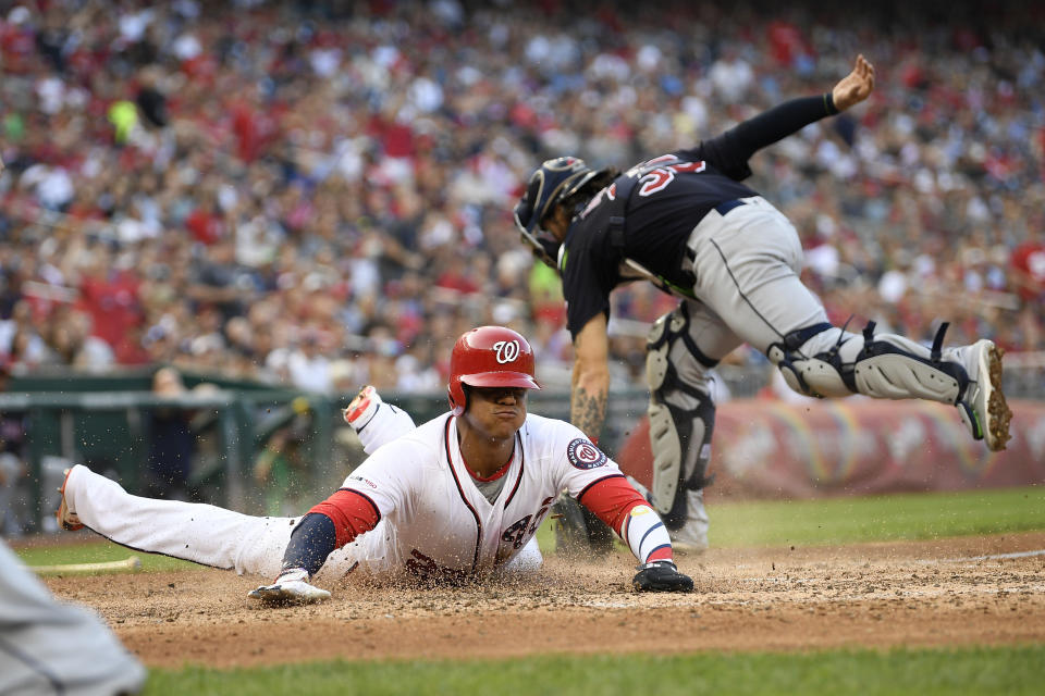 Washington Nationals' Juan Soto, left, slides home to score against Cleveland Indians catcher Eric Haase, back, during the fourth inning of a baseball game, Saturday, Sept. 28, 2019, in Washington. (AP Photo/Nick Wass)