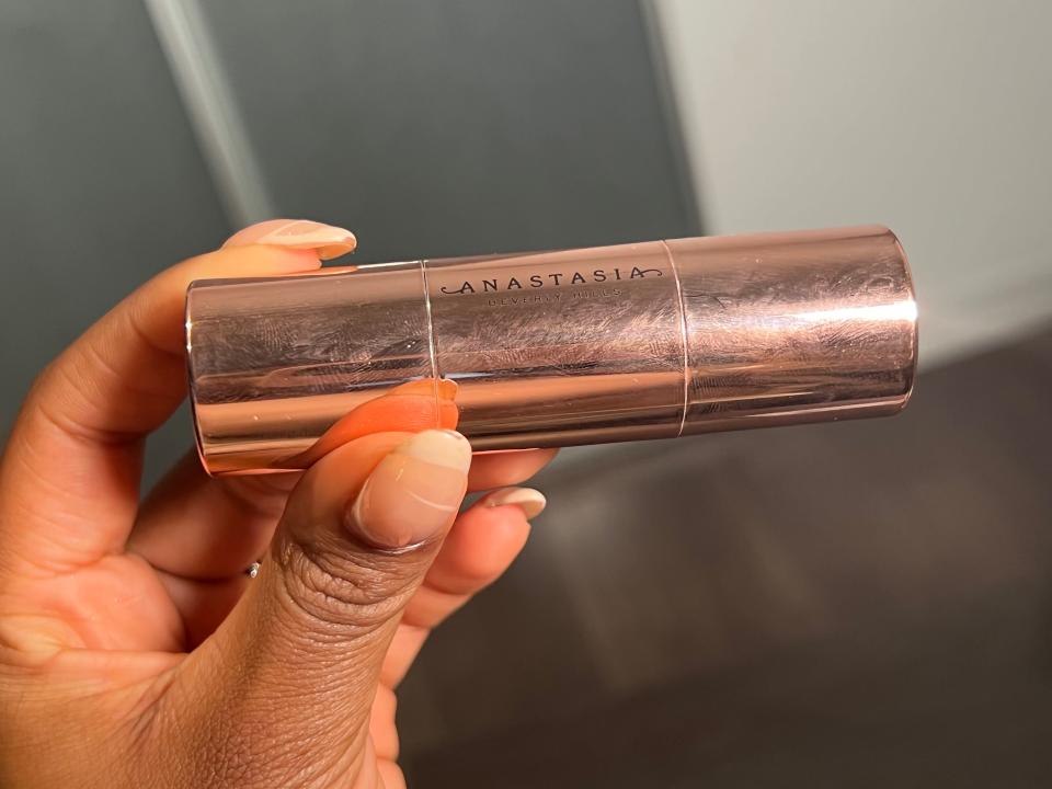 The writer holds a gold tube with "Anastasia" text on it