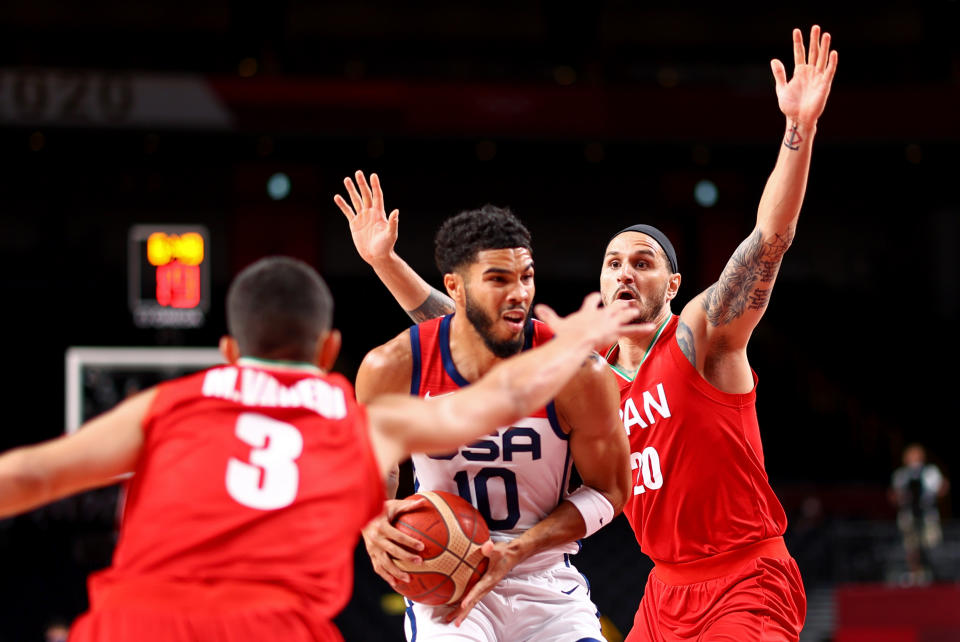 Iran players Mohammadsina Vahedi (left) and Miichael Rostampour surround the United States' Jayson Tatum during the men's basketball match at the 2020 Tokyo Olympics. 