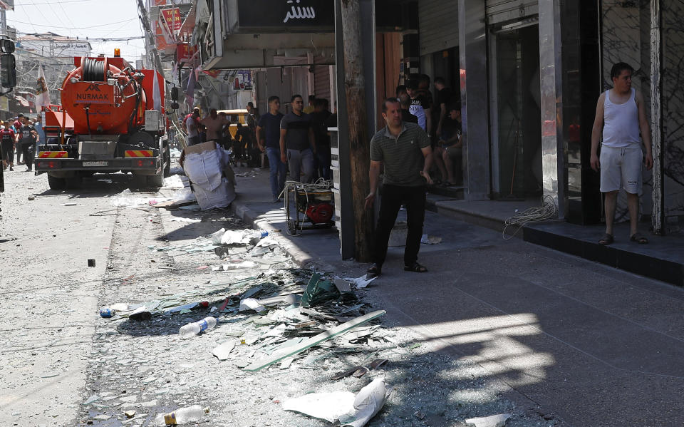 Palestinian merchants clean up their storefronts after an explosion in the Al-Zawiya market area of Gaza City, Thursday, July 22, 2021. At least one person was killed and some 10 injured Thursday when the explosion tore through a house in a popular market, the interior ministry said. (AP Photo/Adel Hana)