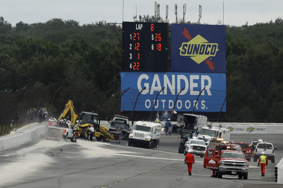 Track workers repair a section of fence after a wreck during the IndyCar auto race at Pocono Raceway, Sunday, Aug. 19, 2018, in Long Pond, Pa. (AP Photo/Matt Slocum)