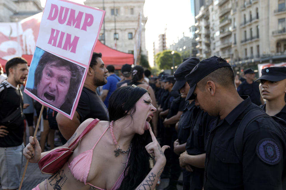 Una manifestante antigubernamental hace un gesto a los policías que custodian el Congreso mientras los legisladores debaten en el interior un proyecto de ley del presidente, Javier Milei, en Buenos Aires, Argentina, el 1 de febrero de 2024. La propuesta incluye una amplia variedad de reformas económicas, administrativas, penales y medioambientales. (AP Foto/Rodrigo Abd)