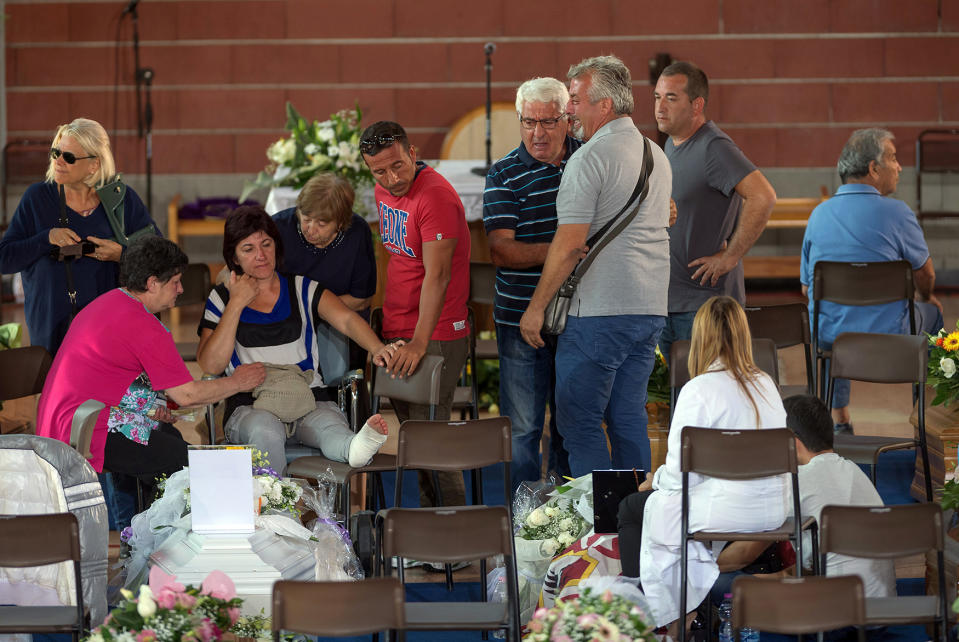 Mourners pay their respects as they attend a funeral