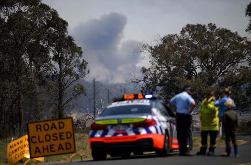 Smoke from a large bushfire is seen from a roadblock outside Wytaliba, near Glen Innes