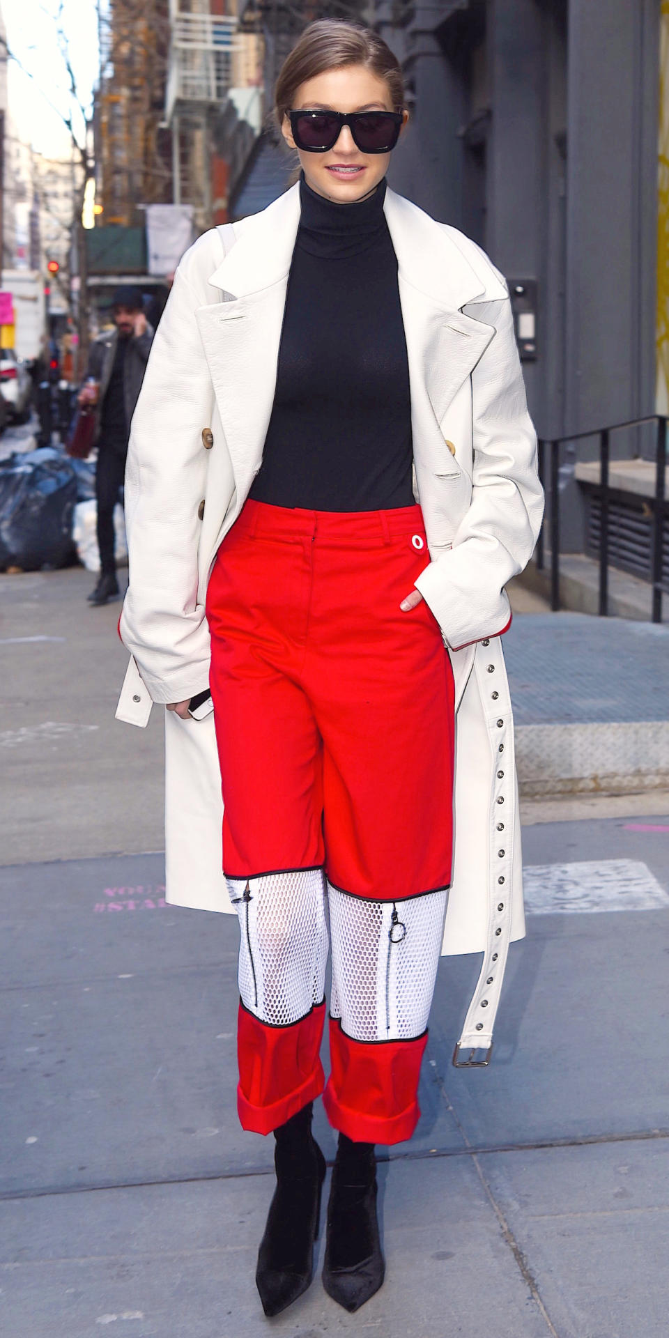 <p>While out in the Big Apple, Hadid donned funky wide-leg red trousers and a black turtleneck that she paired with a long white trench. A pair of pointed suede boots and oversize sunnies completed her ensemble.</p>