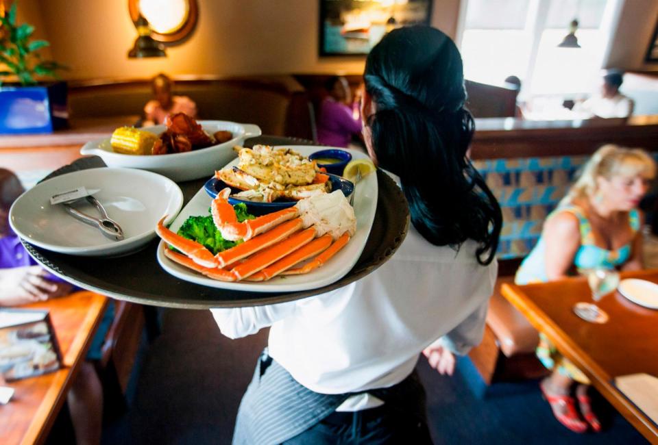 PHOTO: A waitress carries a tray a lobster kettle and a crab trio dish at a Red Lobster restaurant in Yonkers, New York, July 24, 2014. (Michael Nagle/Bloomberg via Getty Images)