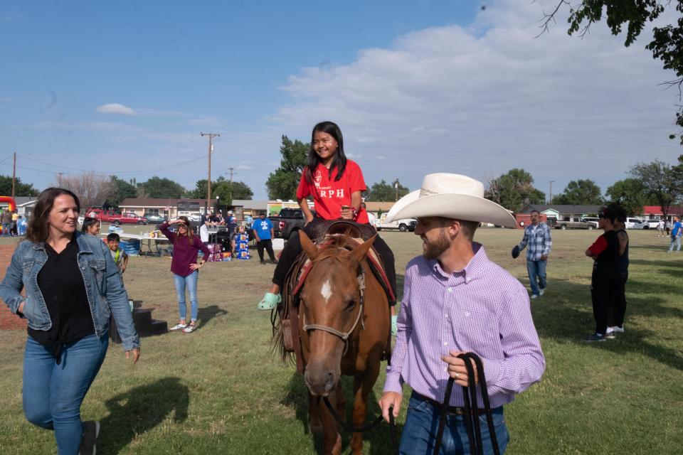 A young child enjoys a short ride on a horse Sunday during the World Refugee Day celebration held at Trinity Fellowship  in Eastridge.