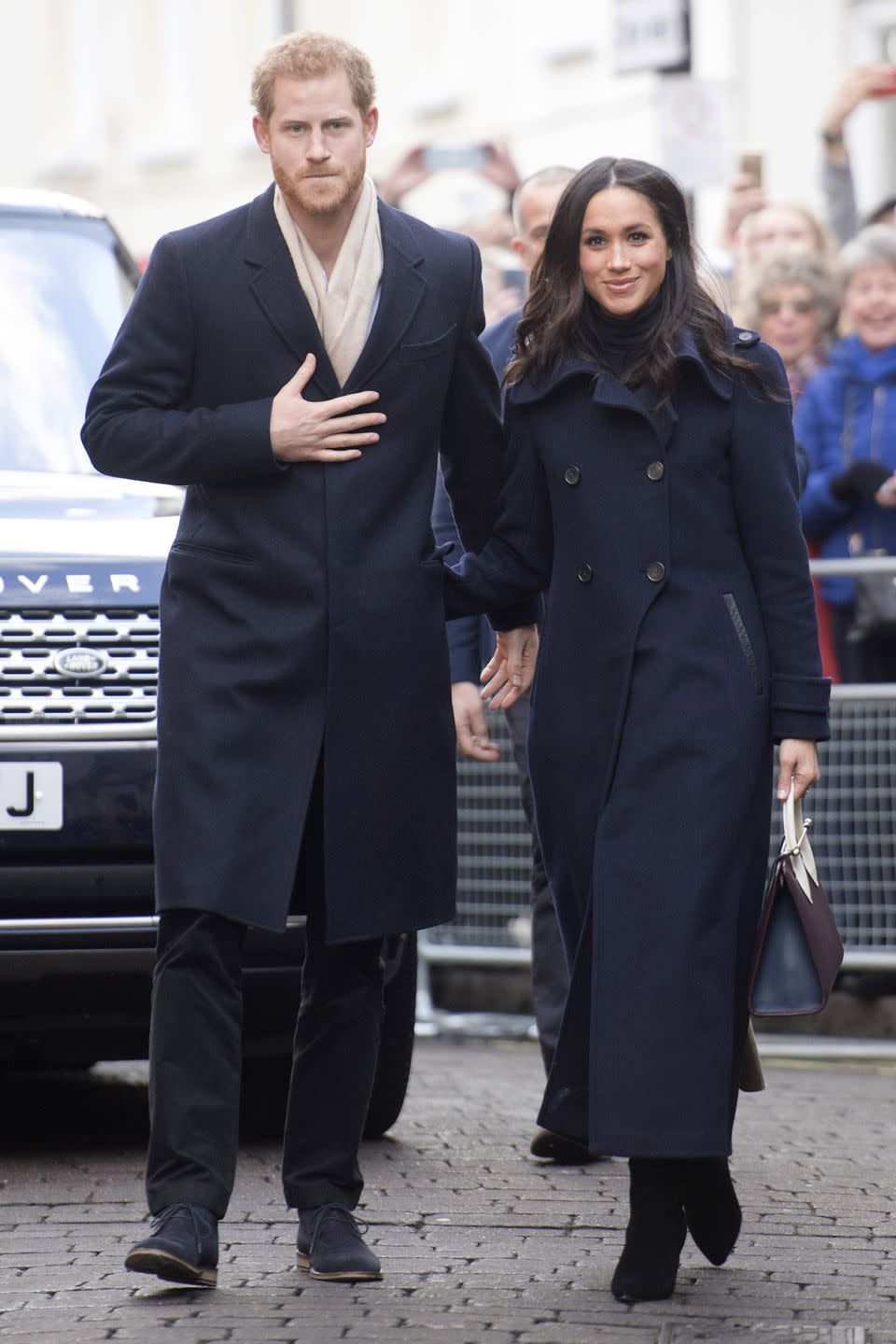 <p>In a Mackage double breasted coat, Wolford turtleneck, Kurt Geiger boots, and Strathberry tote bag during her first royal engagement with Prince Harry in Nottingham, England.</p>