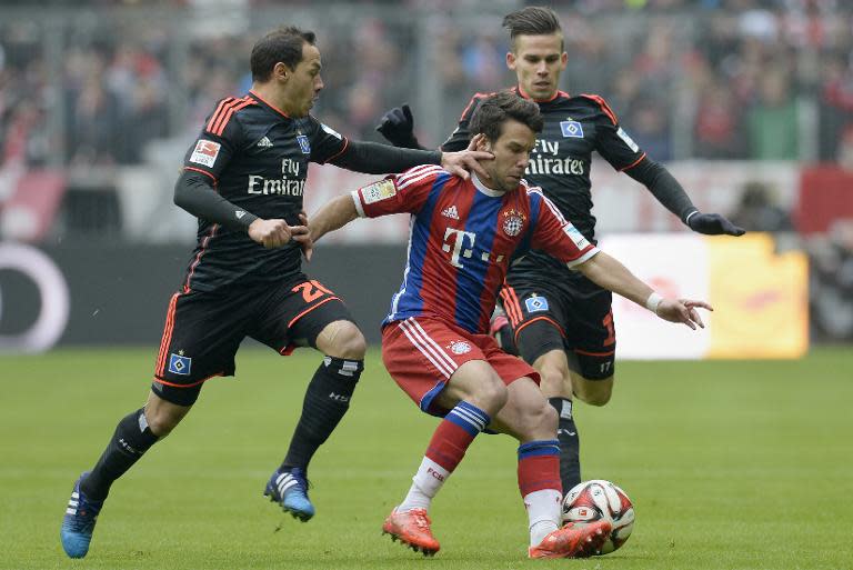 (L-R) Hamburg's Marcelo Diaz, Bayern Munich's Juan Bernat and Hamburg's Zoltan Stieber vie for the ball during their German first division Bundesliga football match in Munich, Germany, on February 14, 2015