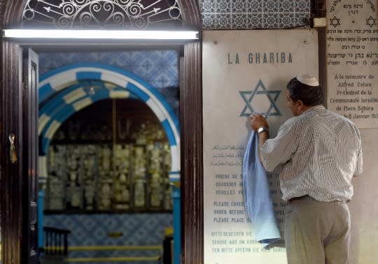 An employee cleans an engraved Star of David at the Ghriba Synagogue on the eve of the annual Jewish pilgrimage, on the Mediterranean island of Djerba, May 5, 2015 (AFP/Fethi Belaid)