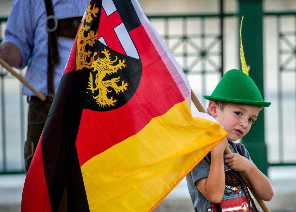 Henry Augspurger, 5, of Groveland holds on tight to a flag he is bearing in the parade of flags to kick off the annual Oktoberfest on Friday, Sept. 20, 2019, in Peoria.