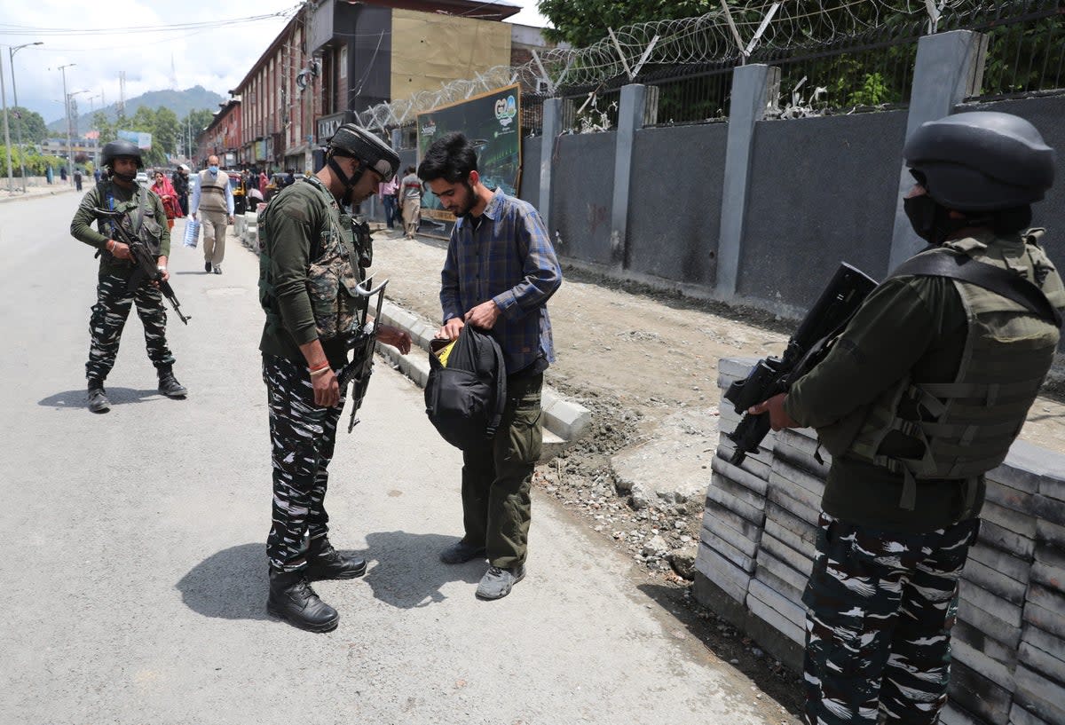 An Indian paramilitary soldier checks bag of a Kashmiri man during a surprise search operation as security is being beefed up ahead of the G20 meetings (EPA)