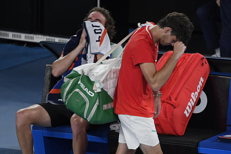 Taylor Fritz, right, of the U.S. walks from Rod Laver Arena after his fourth round loss to Stefanos Tsitsipas of Greece at the Australian Open tennis championships in Melbourne, Australia, early Tuesday, Jan. 25, 2022. (AP Photo/Andy Brownbill)