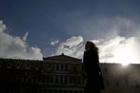 A woman is silhouetted as she makes her way in front of the parliament building in Athens, February 18, 2015. REUTERS/Alkis Konstantinidis