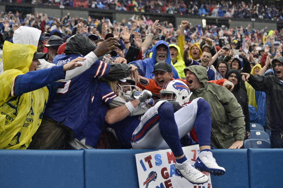 Buffalo Bills tight end Dawson Knox, center, is mobbed by fans after scoring a 1-yard touchdown during the second half of an NFL football game against the Houston Texans, Sunday, Oct. 3, 2021, in Orchard Park, N.Y. (AP Photo/Adrian Kraus)