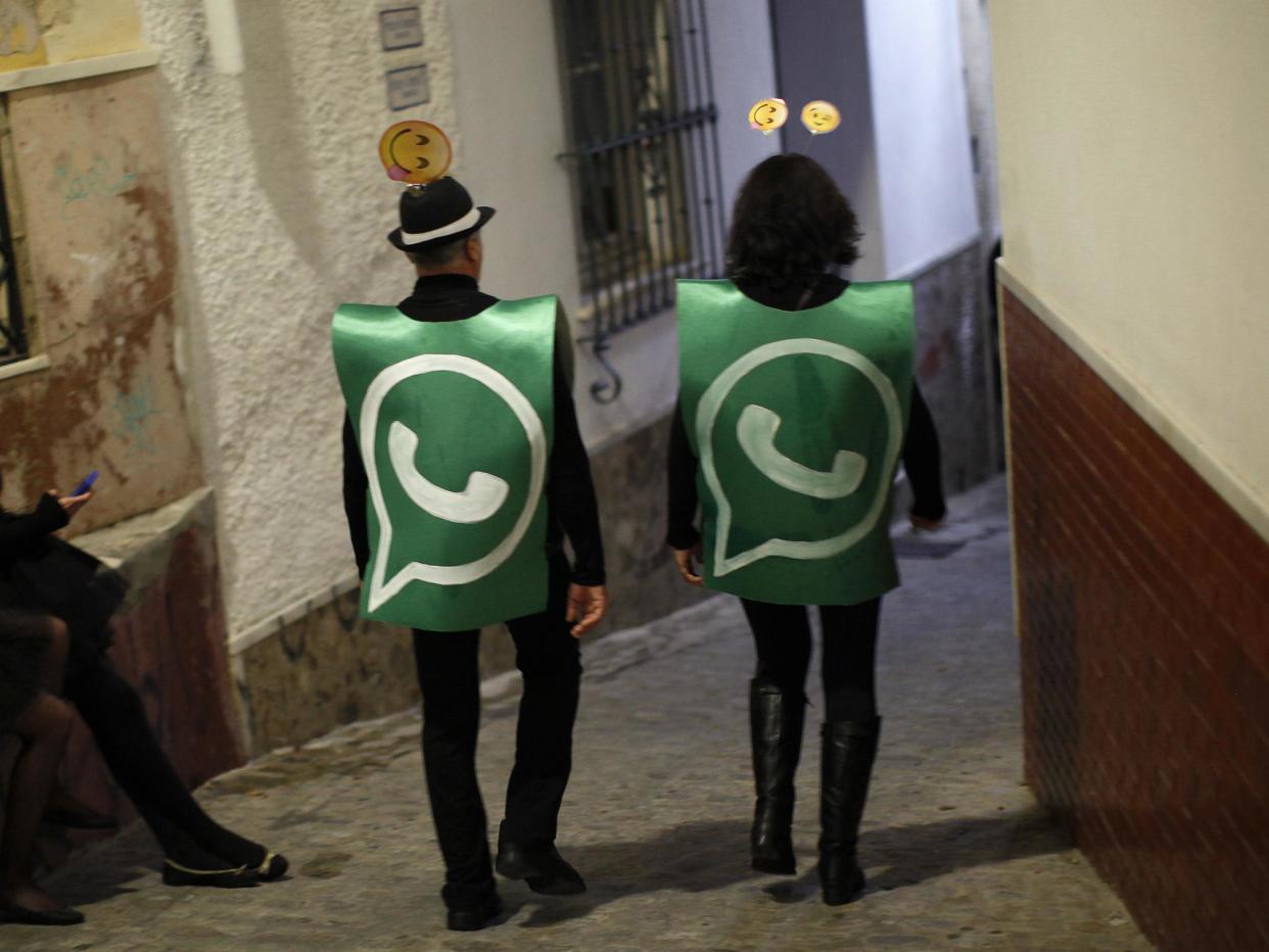 Revellers dressed up as dancers of 'Black Swan' check their mobile phones next to revellers dressed up as a Whatsapp logo as they take part in New Year's celebrations in Coin, near Malaga, southern Spain, early January 1, 2015: REUTERS/Jon Nazca