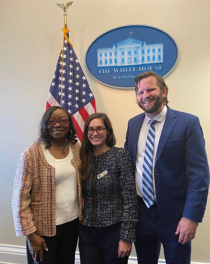 City Commissioners Dianne Williams-Cox, Jack Porter, and Jeremy Matlow pose in front of a White House plaque at the Biden-Harris administration's Communities in Action program event.