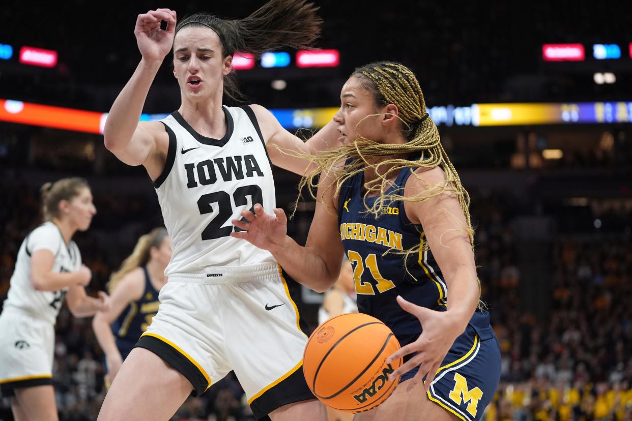 Michigan forward Chyra Evans (22) works toward the basket as Iowa guard Caitlin Clark (22) defends during the first half in the semifinals of the Big Ten women's tournament at Target Center in Minneapolis on Saturday, March 9, 2024.