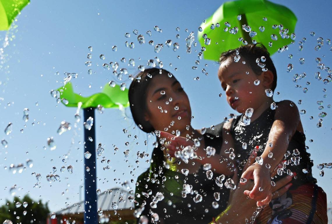 Water seems frozen in air as Bailee Liggett helps keep her son Zaire Prince, 1, cool at Martin Ray Reilly Park’s splash park on a hot Wednesday afternoon, Sept. 7, 2022 in Fresno.