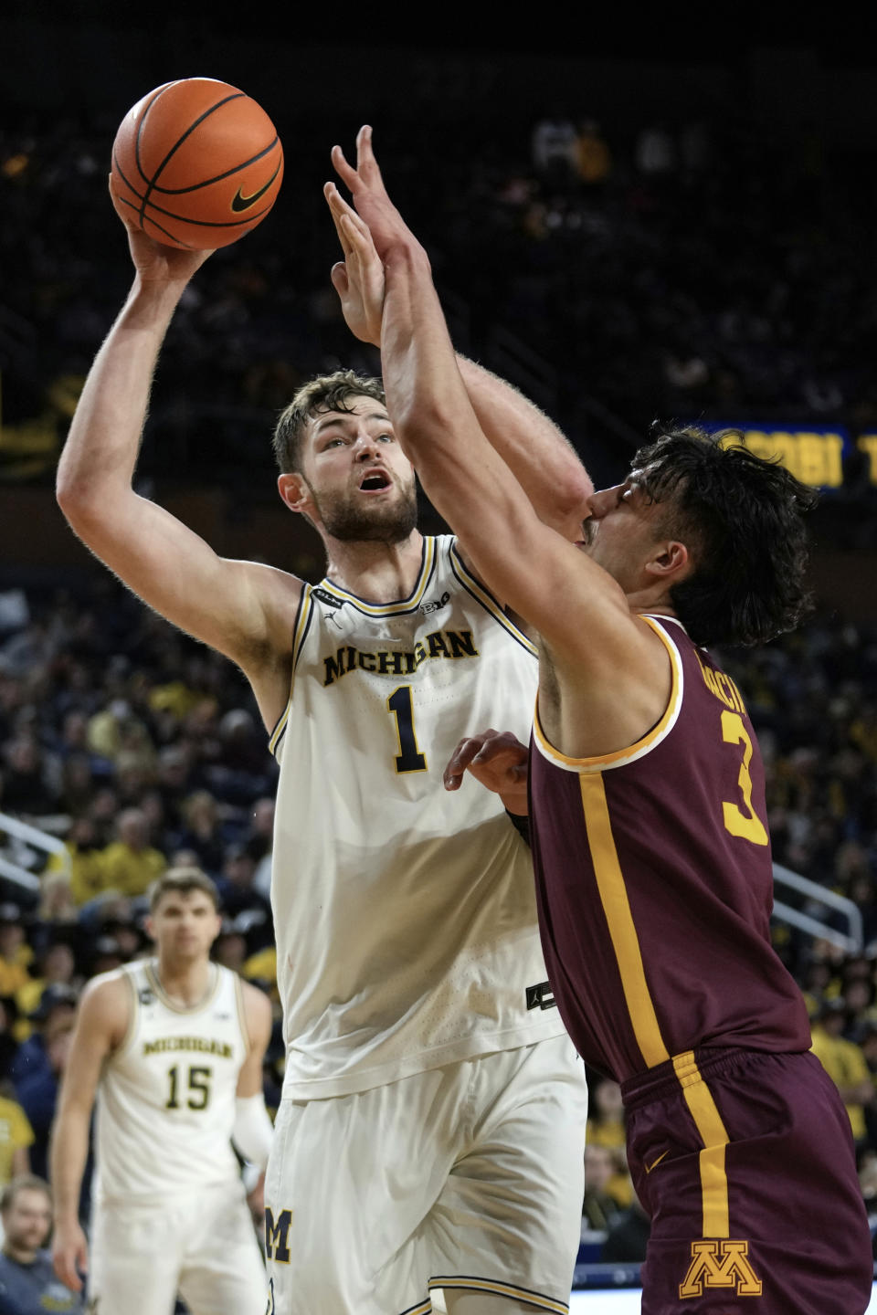 Michigan center Hunter Dickinson (1) shoots on Minnesota forward Dawson Garcia (3) in the second half of an NCAA college basketball game in Ann Arbor, Mich., Sunday, Jan. 22, 2023. (AP Photo/Paul Sancya)