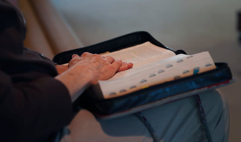 Gail Farnham, longtime parishioner of First Baptist Church, rests her hands on her Bible as she follows along during the sermon given by pastor Ryan Burge in Mt. Vernon, Ill., Sunday, Sept. 10, 2023. | Jessie Wardarski