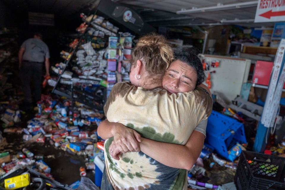 Cassandra Randall, right, is hugged by Jessica Downey inside Maddie's Market on Friday after Hurricane Helene flooded the Steinhatchee grocery store. Randall's mother-in-law manages the store.