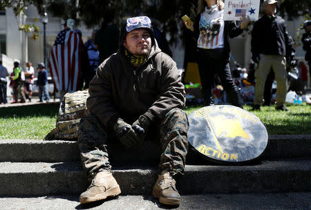 A man looks on as opposing factions gather over the cancelation of conservative commentator Ann Coulter's speech at the University of California, Berkeley, in Berkeley, California, U.S., April 27, 2017. REUTERS/Stephen Lam