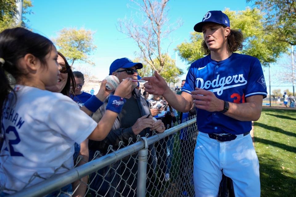 Los Angeles Dodgers starting pitcher Tyler Glasnow signs autographs for fans during spring training baseball workouts at Camelback Ranch in Phoenix, Friday, Feb. 16, 2024. (AP Photo/Ashley Landis)