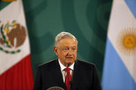 Mexican President Andrés Manuel López Obrador gives his daily, morning press conference at the National Palace in Mexico City, Tuesday, Feb. 23, 2021, with an Argentine flag in the background, right, as Argentine President Alberto Fernandez attends the event. (AP Photo/Marco Ugarte)