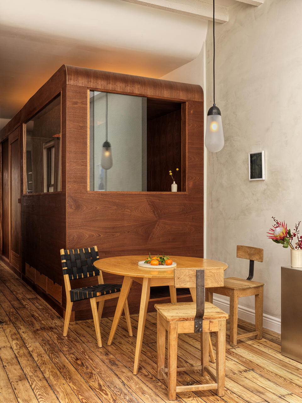 round wood dining table with wood chair, next to wooden box bedroom