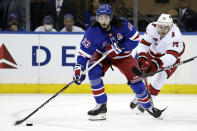 New York Rangers center Mika Zibanejad (93) passes in front of Carolina Hurricanes defenseman Brady Skjei in the first period of Game 3 of an NHL hockey Stanley Cup second-round playoff series, Sunday, May 22, 2022, in New York. (AP Photo/Adam Hunger)