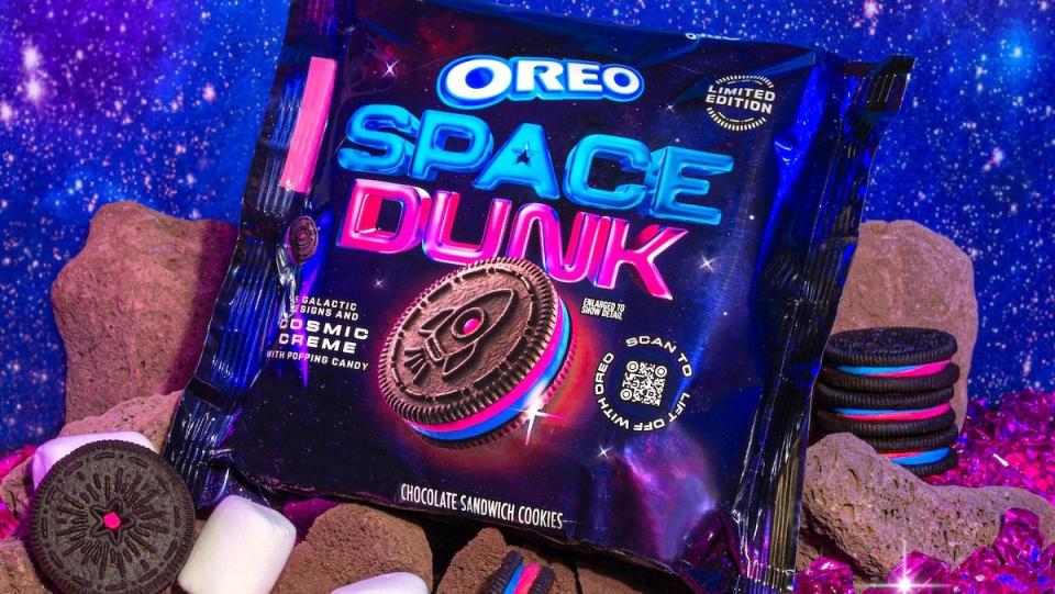 A package of Oreo Space Dunk cookies with a blue and pink color scheme atop rocks, cookies, and marshmallows