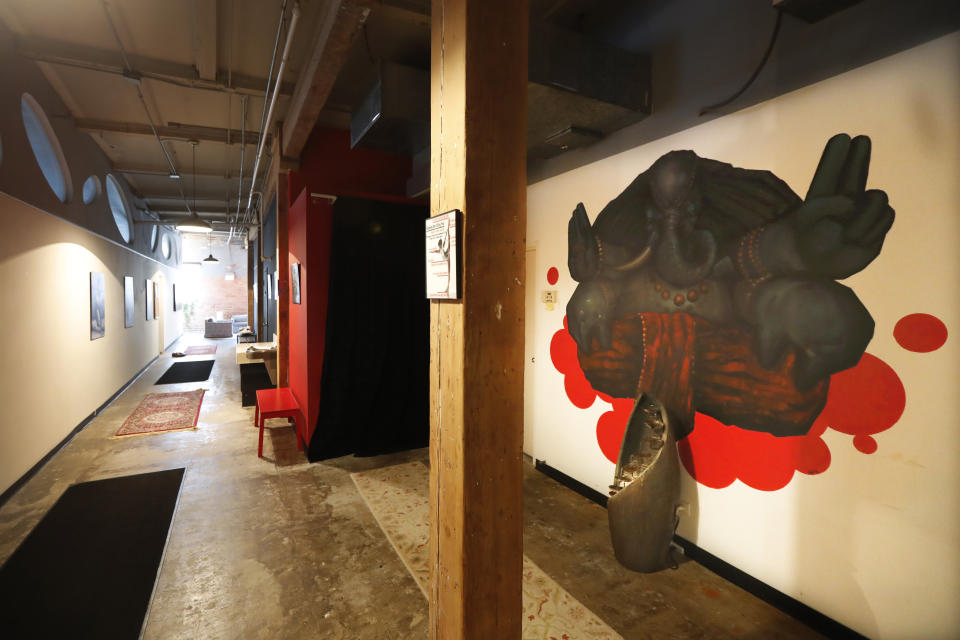 In this April 1, 2020, photo, the long hallway inside Naveed Abidi's Bikram Yoga West is empty of members after being closed by the city last week, tipped off by several residents who disagreed with it being an essential health and wellness center in Chicago. "It was not like an act of rebellion or anything," said Abidi, who faces a fine of up to $10,000. "If we were naughty with the government's order, then we're very, very sorry. We're not here to cause problems, we're here to practice our poses." (AP Photo/Charles Rex Arbogast)