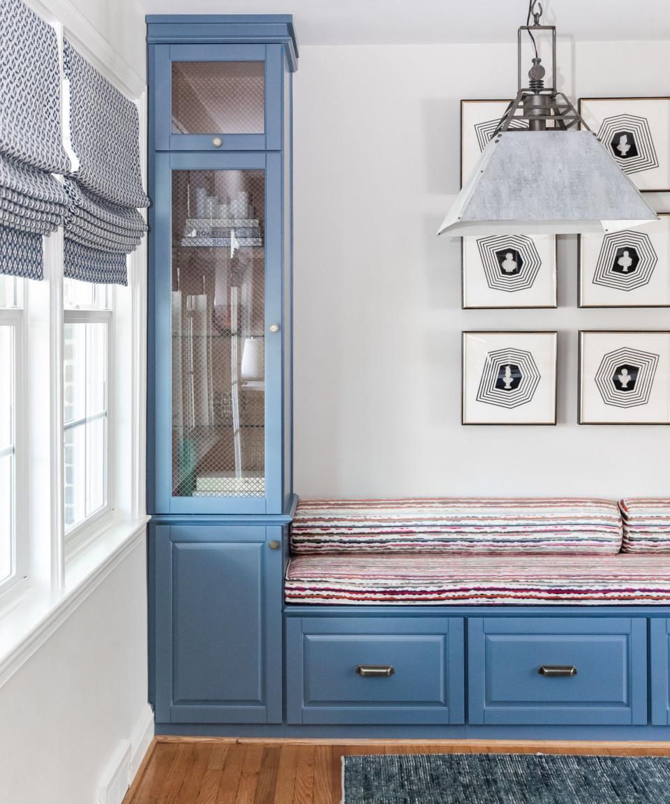 bench seat with red striped cushions and blue cabinetry with cupboards