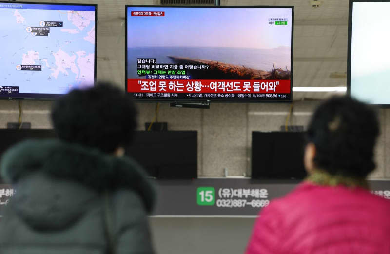 Passengers watch the news on North Korea's latest artillery provocation at a ferry terminal in Incheon. -/YNA/dpa