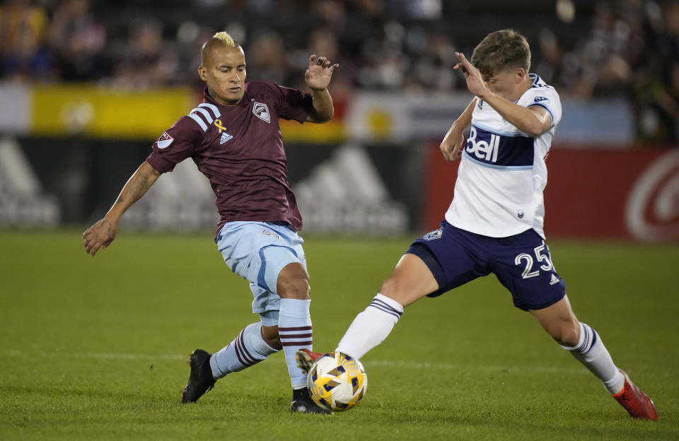 Colorado Rapids forward Michael Barrios, left, pursues the ball with Vancouver Whitecaps midfielder Ryan Gould in the first half of an MLS soccer match Sunday, Sept. 19, 2021, in Commerce City, Colo. (AP Photo/David Zalubowski)