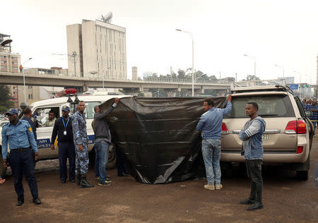 Investigators cover the body of Simegnew Bekele Ethiopia's Grand Renaissance Dam Project Manager who was found dead in his car in Addis Ababa, Ethiopia July, 26, 2018 REUTERS/Tiksa Negeri