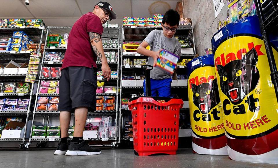 Anthony Lopez, left, and his son, Mark, 11, load up for the Fourth of July celebration while shopping at Save-U-More Fireworks, in Kansas City, Kansas in 2021.