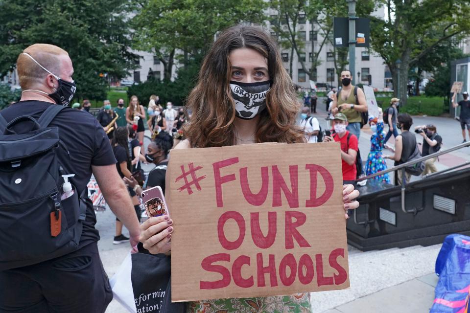 A protester holds a placard that says Fund Our Schools during a demonstration in New York City earlier this month. Several groups, including the United Federation of Teachers, gathered on the National Day of Resistance to protest against reopening of schools as well as for removing police from schools. (Ron Adar/SOPA Images/LightRocket via Getty Images)